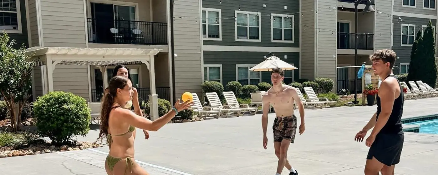 Residents playing spike ball by the pool at The Harbor