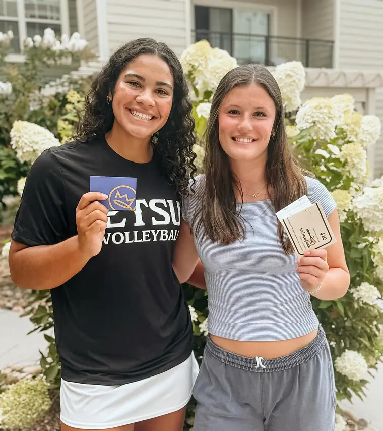 Two ETSU students holding Harbor Yacht Club cards